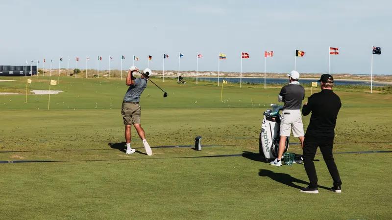 Two golfers practicing on Kiawah Island's scenic course, showcasing flags and rolling greens