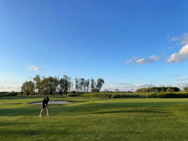 Scenic view of a golfer playing on a sunny day in Trzciana, Poland